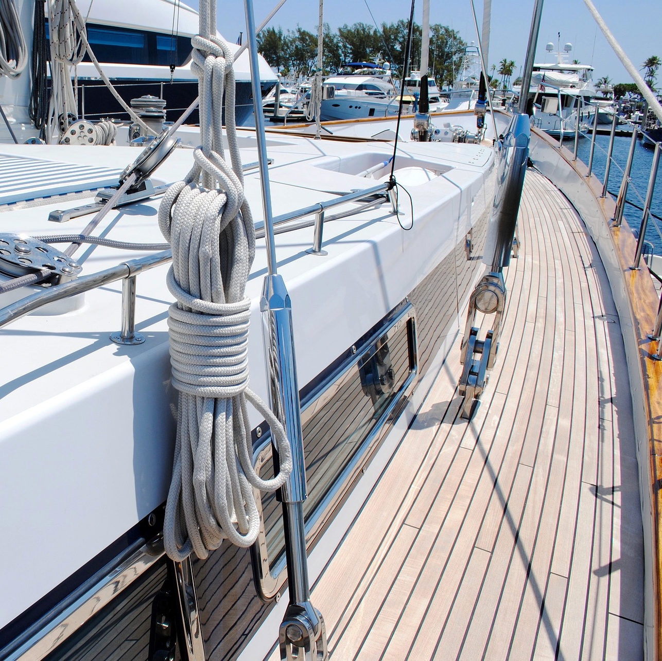 Das Deck einer Segelyacht im Hafen, mit aufgerollten Seilen und einem Polster.